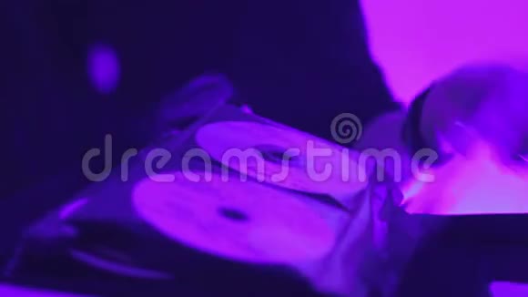 女性DJ在俱乐部演出期间翻页音乐CD收藏视频的预览图