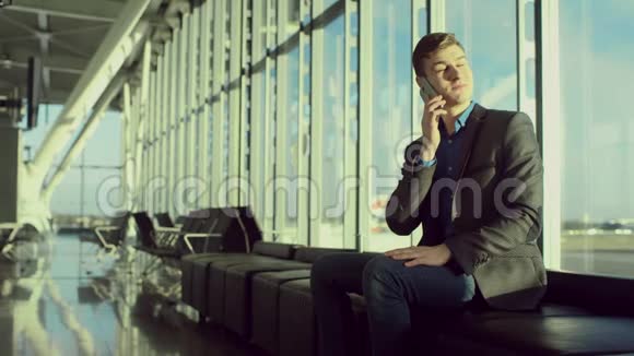 年轻漂亮的男人在机场用手机说话视频的预览图