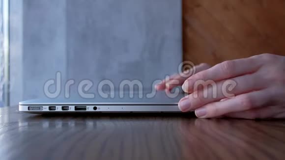 女人的手打开笔记本电脑在工作场所打字视频的预览图