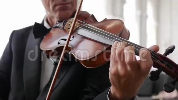 身着古装的小提琴手面目全非男手在木制小提琴上演奏视频的预览图