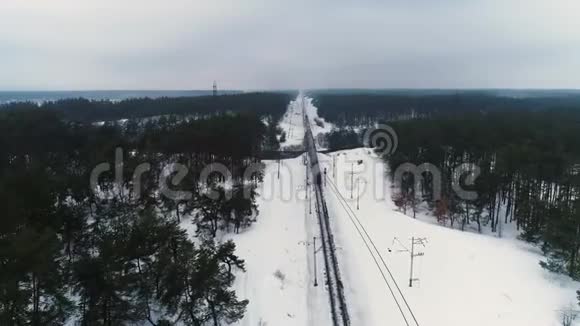 空中无人机镜头在冬季森林里的火车后面视频的预览图