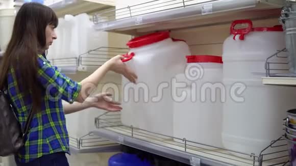 一个年轻的女人在超市里选择一个大水箱视频的预览图