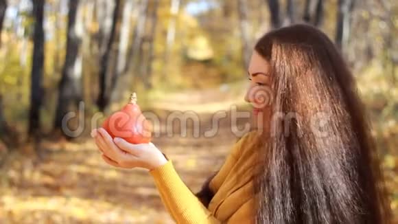 在森林里一个秋天的晴天长发美女手捧南瓜视频的预览图