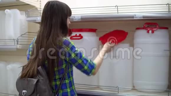 一个年轻的女人在超市里选择一个大水箱视频的预览图