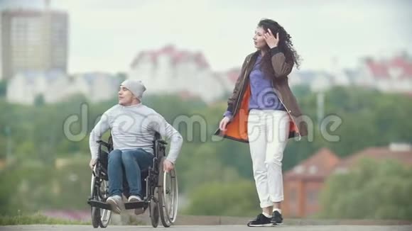 坐轮椅的残疾人和女朋友一起在码头上散步视频的预览图