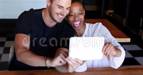 快乐情侣在数码平板电脑上自拍视频的预览图