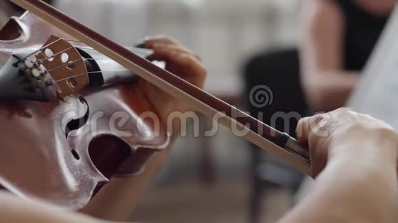 在交响音乐会上演奏木制小提琴弓演奏的人视频的预览图
