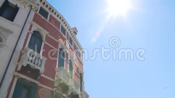 明亮的太阳在蓝色的天空中照耀着古老的巴洛克建筑前往威尼斯视频的预览图