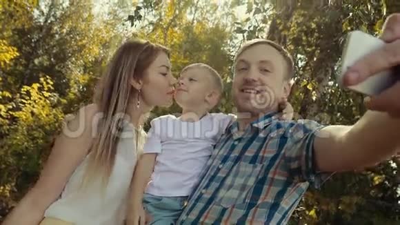 爱的家人在绿色森林里拍照妈妈吻了小儿子视频的预览图