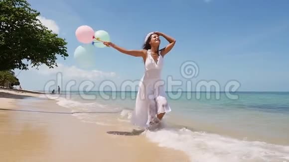 快乐迷人的黑发女孩跑在热带海滩手里拿着气球慢动作概念幸福自由视频的预览图