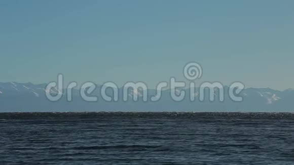 贝加尔湖另一边的山顶完美平静的蓝色背景装载视频的预览图