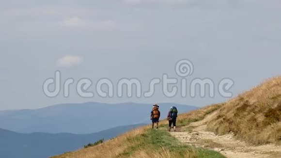 山顶上的几个游客在看山徒步情侣游享生活风景自然景观夏季视频的预览图
