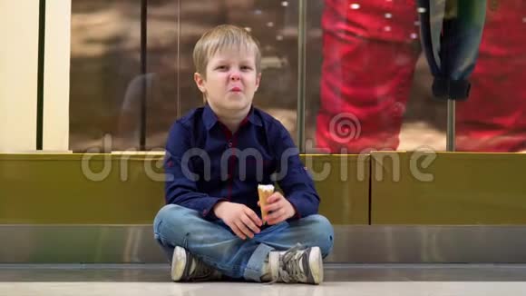 这个可爱的男孩在圣诞节买东西时吃冰淇淋在节日假期购物圣诞节购物男孩视频的预览图