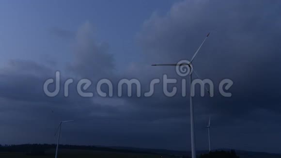 剪影式风力涡轮机农场覆盖着黄昏的天空和白云旋转风力发电厂时间表视频的预览图