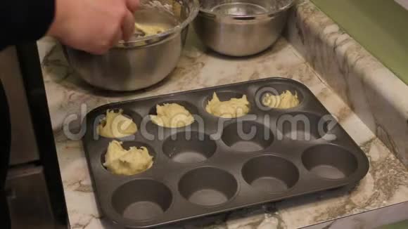 近距离观看女性手把面团从糕点袋放入纸杯在烘焙托盘视频的预览图