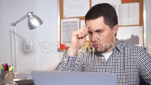 一个在办公室工作的精力集中的人正试图决定买一台笔记本电脑视频的预览图