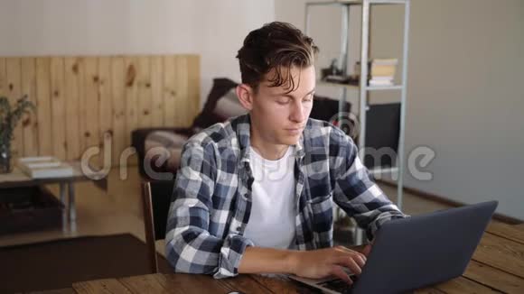 帅哥在笔记本电脑上工作在电话里聊天视频的预览图