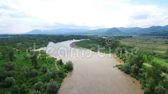 飞行无人机飞过一条大河在美丽的山脉背景上洪水漫山遍野视频的预览图