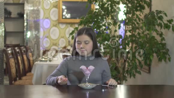 年轻的黑发女孩在舒适的气氛中玩食物在高档的餐厅里扔糖果视频的预览图
