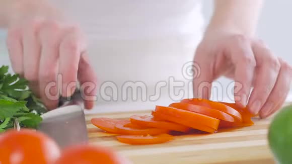 一个女人在厨房里切一个西红柿准备一份美味的新鲜蔬菜沙拉作为午餐视频的预览图