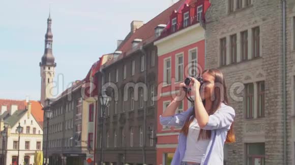 迷人的年轻女孩旅行和探索美丽的古镇带复古相机的游客视频的预览图