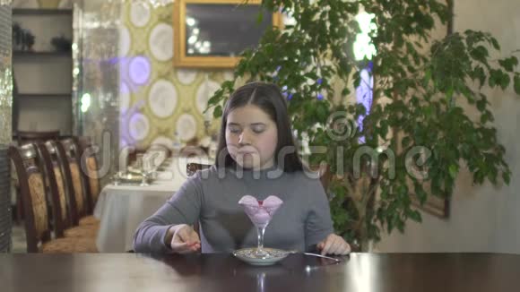 年轻的黑发女孩在高档舒适的气氛餐厅里玩食物把糖果扔到空中视频的预览图