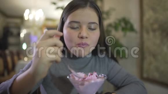 近距离观看胖嘟嘟的黑发少女吃紫罗兰色冰淇淋弄得嘴唇脏兮兮的微笑视频的预览图