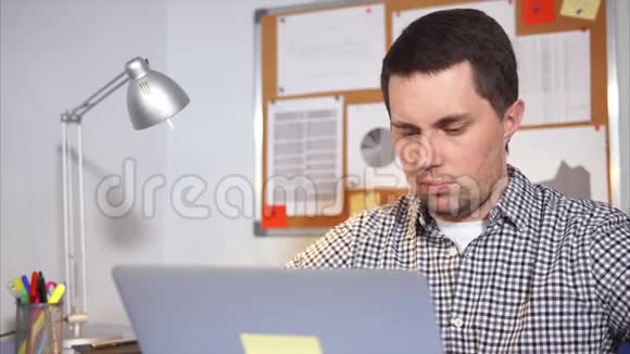 一个年轻人在笔记本电脑上用视频和互联网和父母交谈视频的预览图