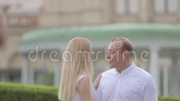 一男一女在大皇宫旁的公园里迷人夫妇的爱情故事美丽的绿色背景视频的预览图
