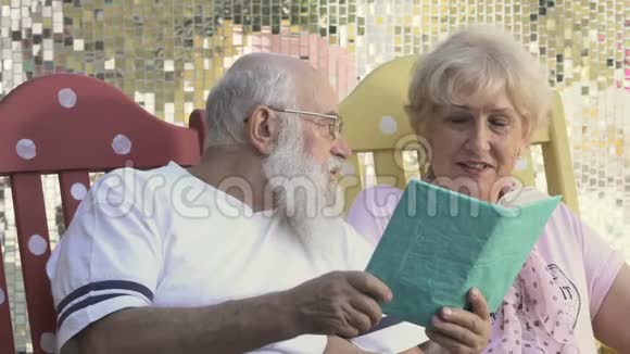 老人在摇椅上看书丈夫亲吻妻子的脸颊视频的预览图