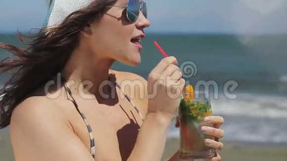 在夏季度假胜地的海滩上为快乐美丽的女性提供鸡尾酒视频的预览图
