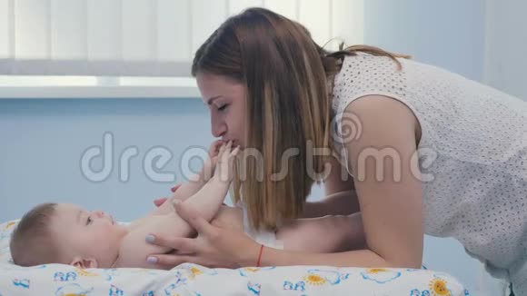 可爱的妈妈吻她小儿子的手指视频的预览图