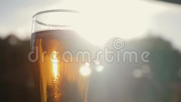 一杯冰啤酒贴在天空一个黄色的夕阳视频的预览图