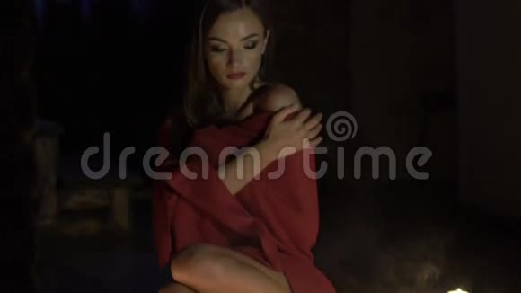热情的孤独女孩坐在灯光旁边蜡烛看着相机慢慢地视频的预览图