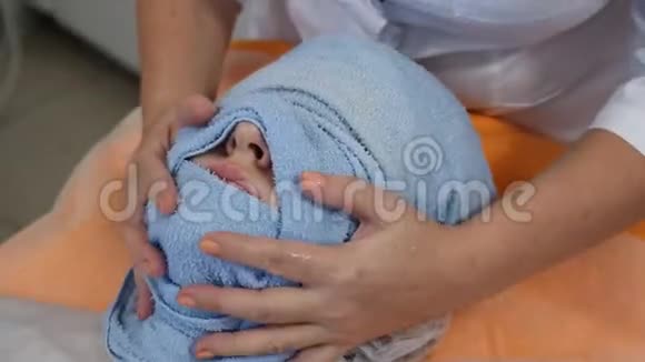 美的概念手术前用毛巾将女性面部包裹起来以暖和面部皮肤面部视频的预览图