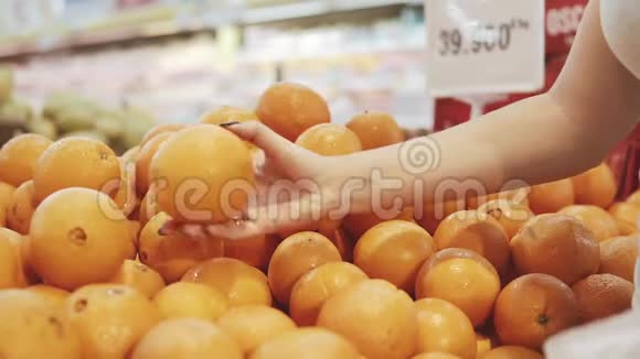 年轻漂亮的女人在超市为家人购买新鲜健康的橘子和水果手臂选择美味视频的预览图