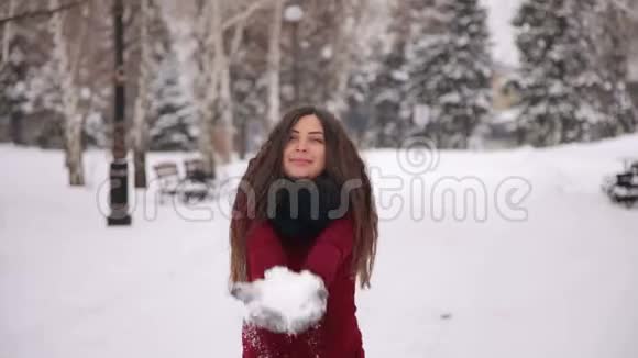 一个怀孕的女孩在冬季公园里扔雪视频的预览图
