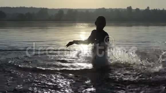 快乐的人会在日落时分在湖中嬉戏视频的预览图