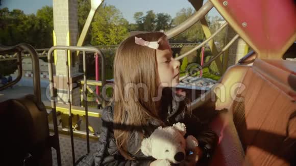 不满意的小女孩坐在童车里等待乞讨视频的预览图