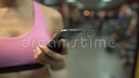 女人在手机上翻页在健身房锻炼后休息视频的预览图
