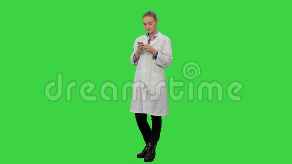 女医生用现代智能手机在绿色屏幕上发短信Chroma键视频的预览图