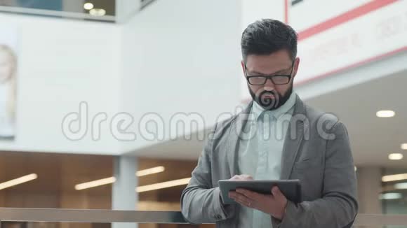 办公中心的商人用平板电脑上网视频的预览图