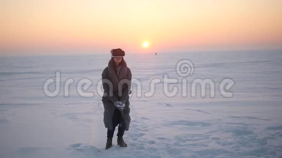 这个女孩在冬天在街上用虚拟现实眼镜欣赏雪景视频的预览图