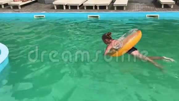 一个十几岁的女孩在游泳池里玩充气圈视频的预览图