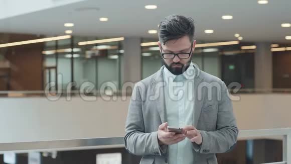 穿西装的商人用小工具手机来处理商业事务视频的预览图