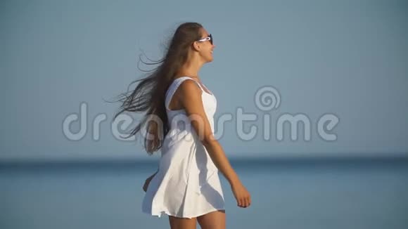 戴太阳镜的女孩在大海的背景下视频的预览图