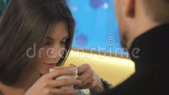 可爱的女孩喝了咖啡男朋友摸了摸她的脸视频的预览图