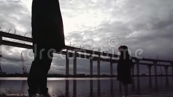 两个人的身影站在河岸上有一座视频的预览图