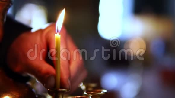 一个人把一支蜡烛放在东正教教堂的祭坛上视频的预览图