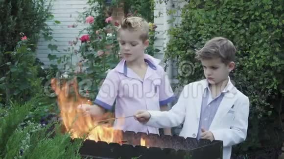 小男孩在烧烤架附近玩火视频的预览图